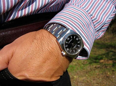 arm met rolex om|wearing a Rolex on wrist.